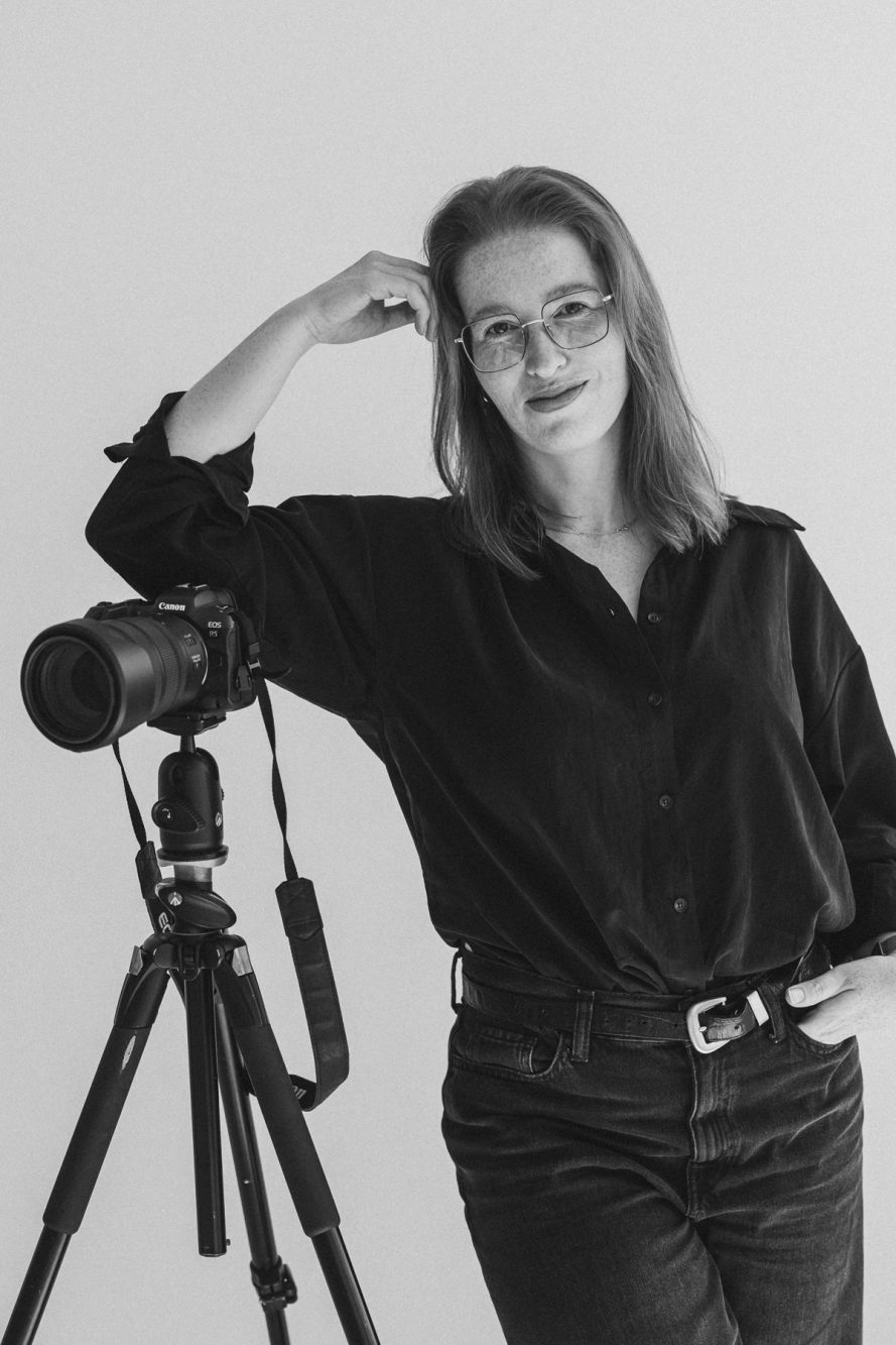 Czarno-biała sesja wizerunkowa fotografki przy statywie