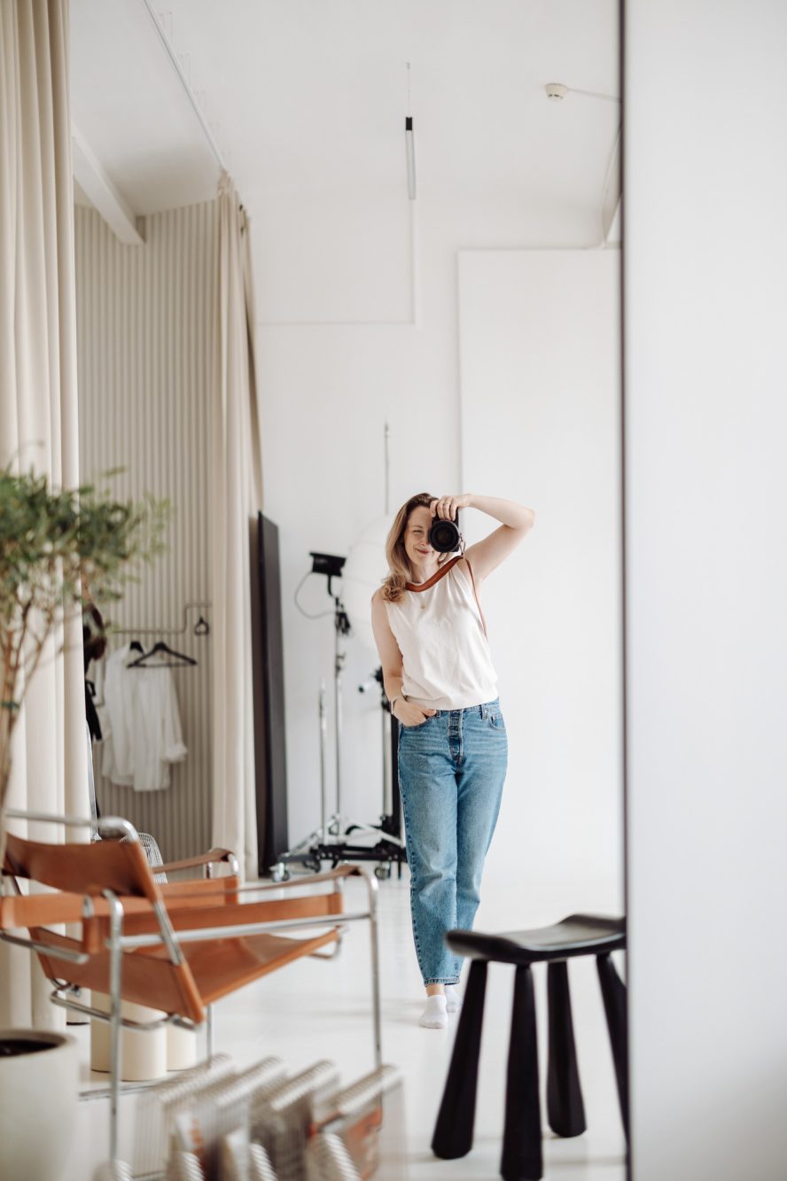 Magdalena Mizera, fotografka z Warszawy, z aparatem w jasnym studiu